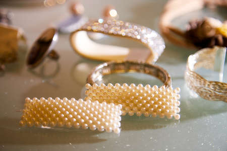 Jewelry for women on glass table illuminated by an interesting light