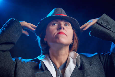 Portrait of ugle middle-aged woman with hat. Model posing in funny male style in the Studio