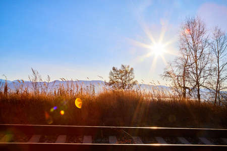 Circum Baikal railway running along the shore of Lake Baikal on an autumn sunny day with yellow landscape aroundの写真素材