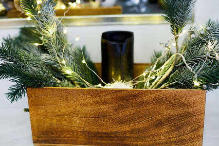 Branches of a Christmas tree in basket and garland