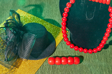 Red beads, bracelet, and an elegant black hat of woman with a veil. The concept of a beautiful,...