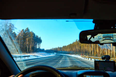 View from of car interior from side of driver to the road and nature landscape through the...