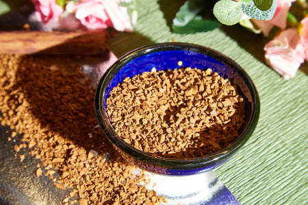 Loose instant coffee in blue beautiful ceramic saucer. Resource for making a delicious coffee drink