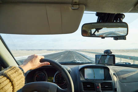 Siberia, Russia - November 28, 2020: View from of car interior from side of driver to the road and nature landscape through windshieldのeditorial素材