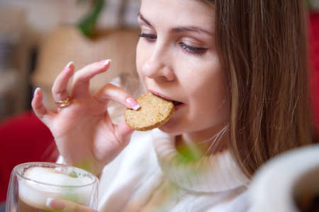 Girl with long hair in a room with a lot of things. Portrait of a young woman in cozy houseの写真素材