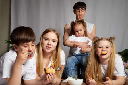 Kirov, Russia - April 25, 2021: Happy big happy family with parents and children eating in room. Mother, father, sisters, brothers having fun togetherのeditorial素材