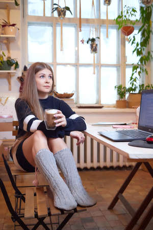 Girl with long hair in a room with a lot of things. Portrait of a young woman in cozy house