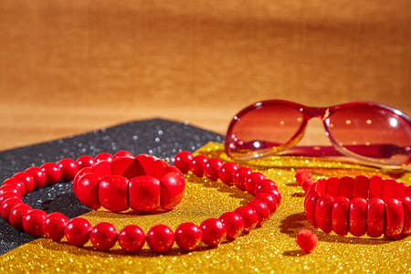 Red beads lying on an unusual surface and red braceletの写真素材