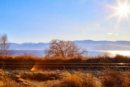 Circum Baikal railway running along the shore of Lake Baikal on an autumn sunny day with yellow landscape aroundの写真素材