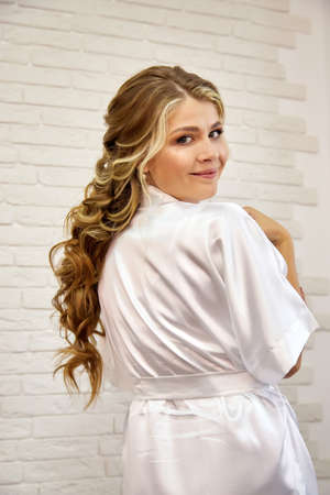 A beautiful bride in the morning with a hairstyle makeup after a visit to a makeup artist and...