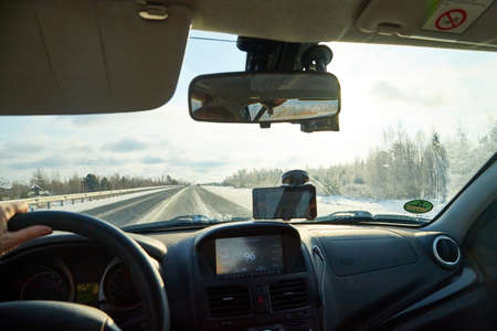 Siberia, Russia - November 28, 2020: View from of car interior from side of driver to the road and nature landscape through windshieldのeditorial素材