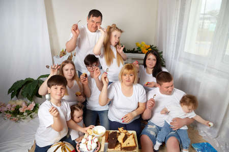 Kirov, Russia - April 25, 2021: Happy big happy family with parents and children eating in room. Mother, father, sisters, brothers having fun togetherのeditorial素材