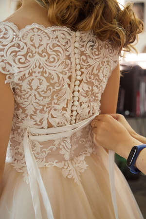 Dressing the dress of bride and lacing the nice corsetの写真素材