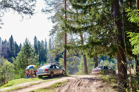 Kirov, Russia - May 09, 2020: Car and people on vacation in the forest on a sunny summer or spring day. Parking of autotourists near treesのeditorial素材
