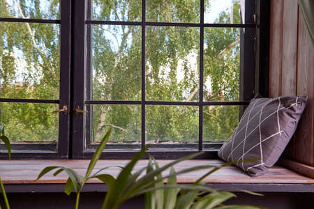 Big wooden window with frame and window sill and nature on the background