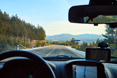 Siberia, Russia - November 28, 2020: View from of car interior from side of driver to the road and nature landscape through windshieldのeditorial素材
