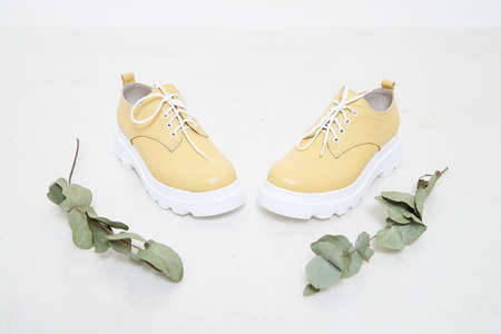 Yellow women sneakers in the studio on white background. Fashion shooting for catalog or store...