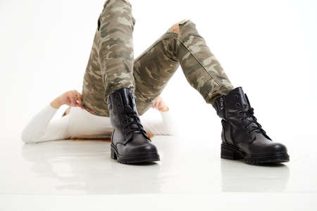 Female winter, autumn or spring black leather shoes on leg of woman in studio on white background. Fashionable modern photography and photoshoot for a store, catalog, magazine or onlineの写真素材