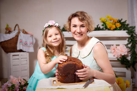 Nice mom and beautiful blonde daughter in room durin spring photo shoot before easter with festive...