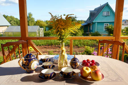 Kirov, Russia - August 07, 2021: Beautiful blue service with a pattern on the table outside. Tea drinking in nature. Expensive Tableware consisting of Mugs, saucers and a teapotのeditorial素材