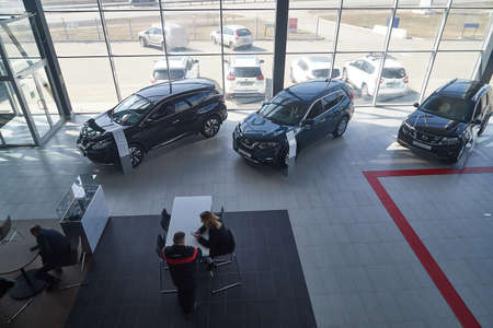Kirov, Russia - April 12, 2022: Manager and seller in showroom with cars of dealership Nissan in...