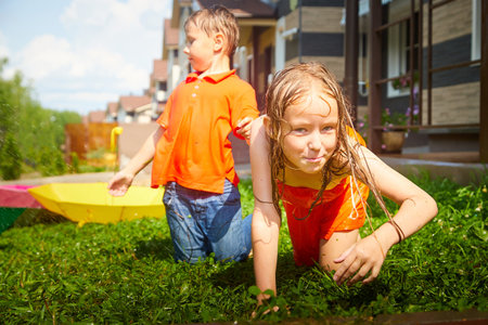 Children having fun and joy with an umbrella on green grass. Boy and girl having rest together. Brother and sister walk on natureの写真素材