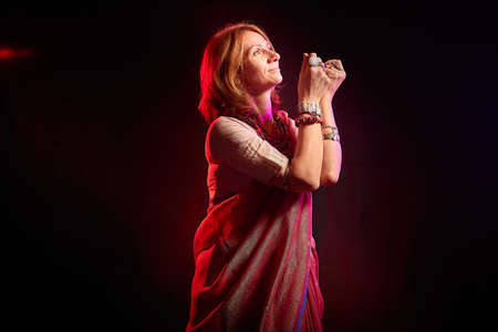 A beautiful European woman in a traditional Indian sari on a black background. Girl model posing in the studioの写真素材