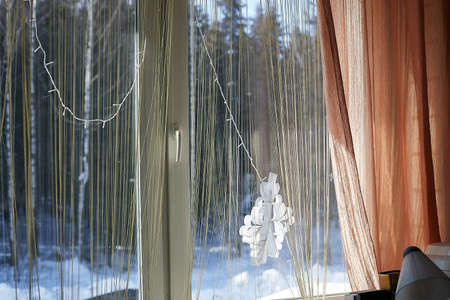 View through the window of cottage into a snow-covered winter forest