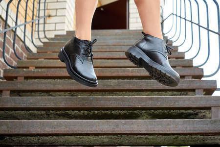 Black female or male leather shoes on legs of woman. Shooting for catalog or an online store...