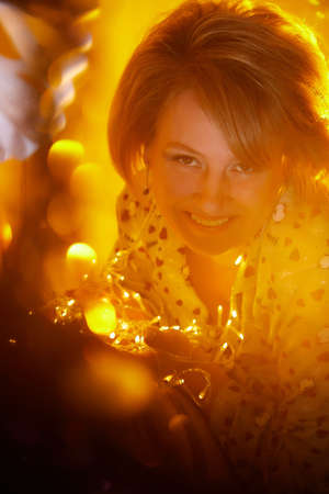 Happy adult middle aged woman wearing pajamas in room with Christmas decorations. New Year holiday in Russiaの写真素材