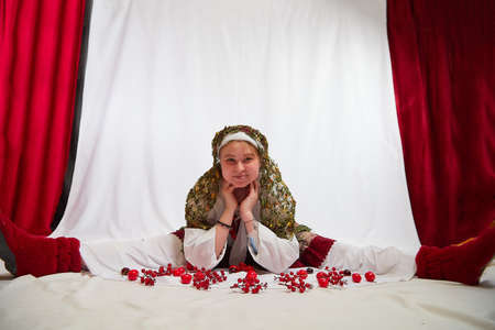 Beautiful smiling girl in stylized slavic red and white national costume on white background. Funny...