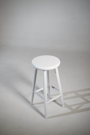 White stool with shadow on white background. Location in studio for photoshoot with tabouret on...