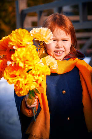 Girl in a snowy city with a bouquet of spring flowers.の写真素材