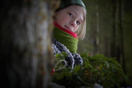 Portrait of a nice cute teenager girl in old peasant clothes with hot fur coat and shawl in cold winter forest with fir trees, pines and snow on winter dayの写真素材