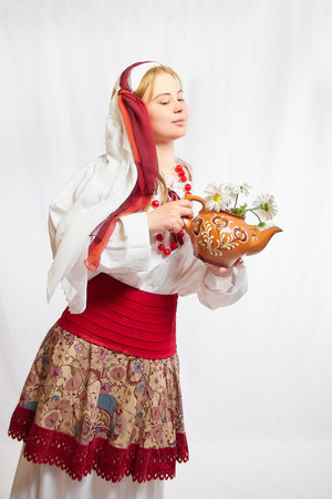 Beautiful smiling girl in stylized slavic red and white national costume on white backgroundの写真素材