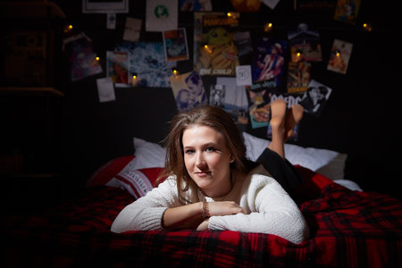 Kirov, Russia - January 04, 2022: Attractive, happy young brunette girl having fun on the bed in room decorated for Christmas and New Yearのeditorial素材