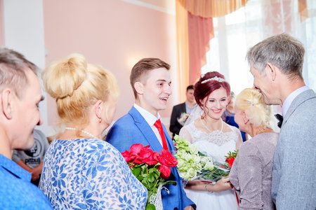 Kirov, RUSSIA - June 20, 2020: Bride and groom at the registry office after the official marriage ceremony and people, friends, relatives, guests congratulating them on their weddingのeditorial素材