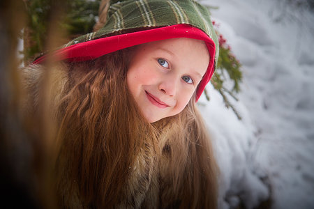 Portrait of a little girl in old peasant clothes including a fur coat and a shawl in cold winter...