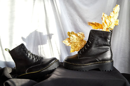 Female winter, autumn or spring black leather shoes in studio. Fashionable modern photography for...