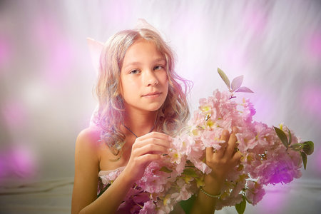 Portrait of cute kid girl posing in pink beautiful dress on a white background. Model in studio looking as gentle magic princess from fairy talyの写真素材