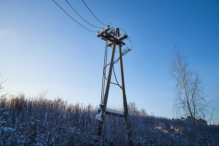 Old wooden power line pole in cold winter day and blue skay backgroundの写真素材