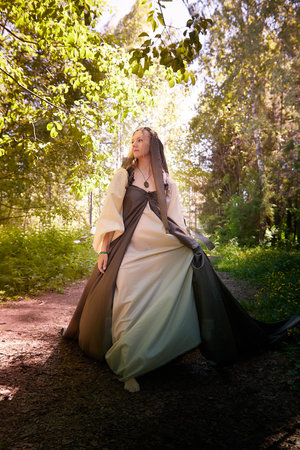 Beautiful seductive dryad. Pagan spirit of the forest. Portrait of beautiful dryad. Fairy who loves nature in beautiful green summer forest. Concept of environmental friendliness and caring for natureの写真素材