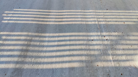 Abstract background with dark and light stripes of shadow on pure white snow on sunny winter cold dayの写真素材