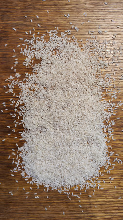 White cereal rice on a brown wooden surface for background and texture. Product and food stored for a long time. Partial focus. Partial focusの写真素材