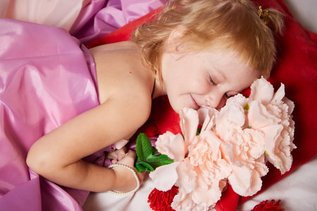 Portrait of cute kid girl posing in pink beautiful dress on a white background. Young female model looking as magic princess from fairy talyの写真素材