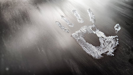 White hand print on black background with stripes. Abstract texture with fingers with partial focusの写真素材