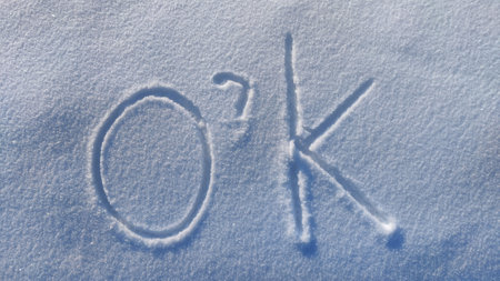 The inscription o'k on the white snow on cold winter sunny day. The concept all will be wellの写真素材
