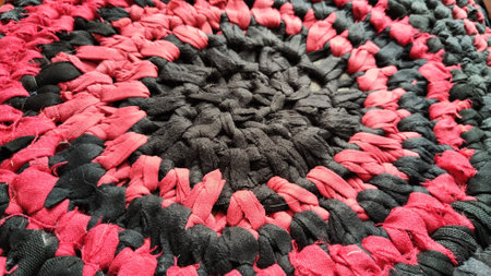 Knitted black and red texture and background. Rurfl rustic traditional round rugの写真素材