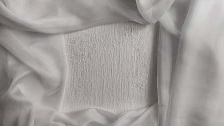 Abstract background with a light delicate white fabric chiffon creating frame around square with...