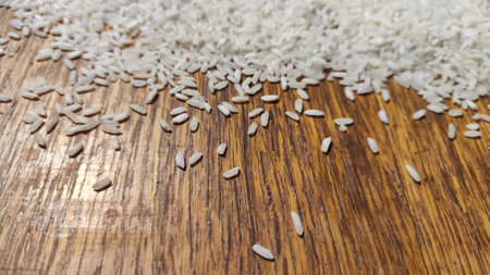 White cereal rice on a brown wooden surface for background and texture. Product and food stored for...